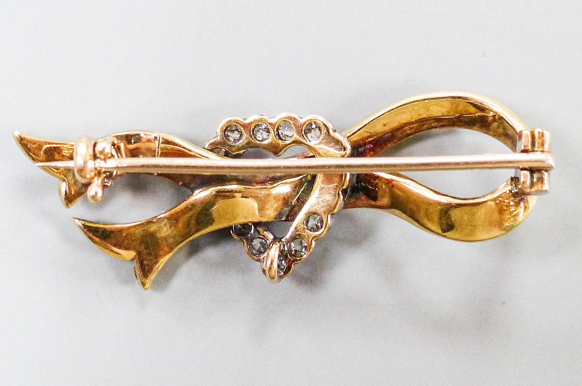 An early 20th century yellow metal, seed pearl and rose cut diamond ribbon and heart brooch, 37mm, gross weight 4.5 grams.